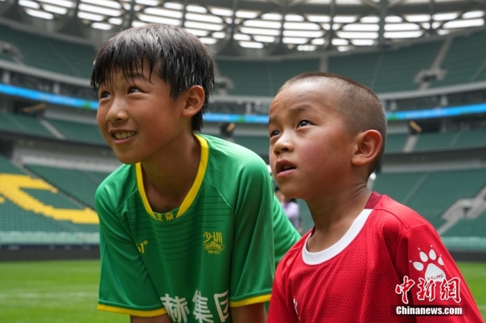 圖為北京國(guó)安小球員陳小北和7歲的俄金仁增在一起觀看場(chǎng)內(nèi)播放的紀(jì)錄片。<a target='_blank' href='/' _fcksavedurl='/'><p  align=