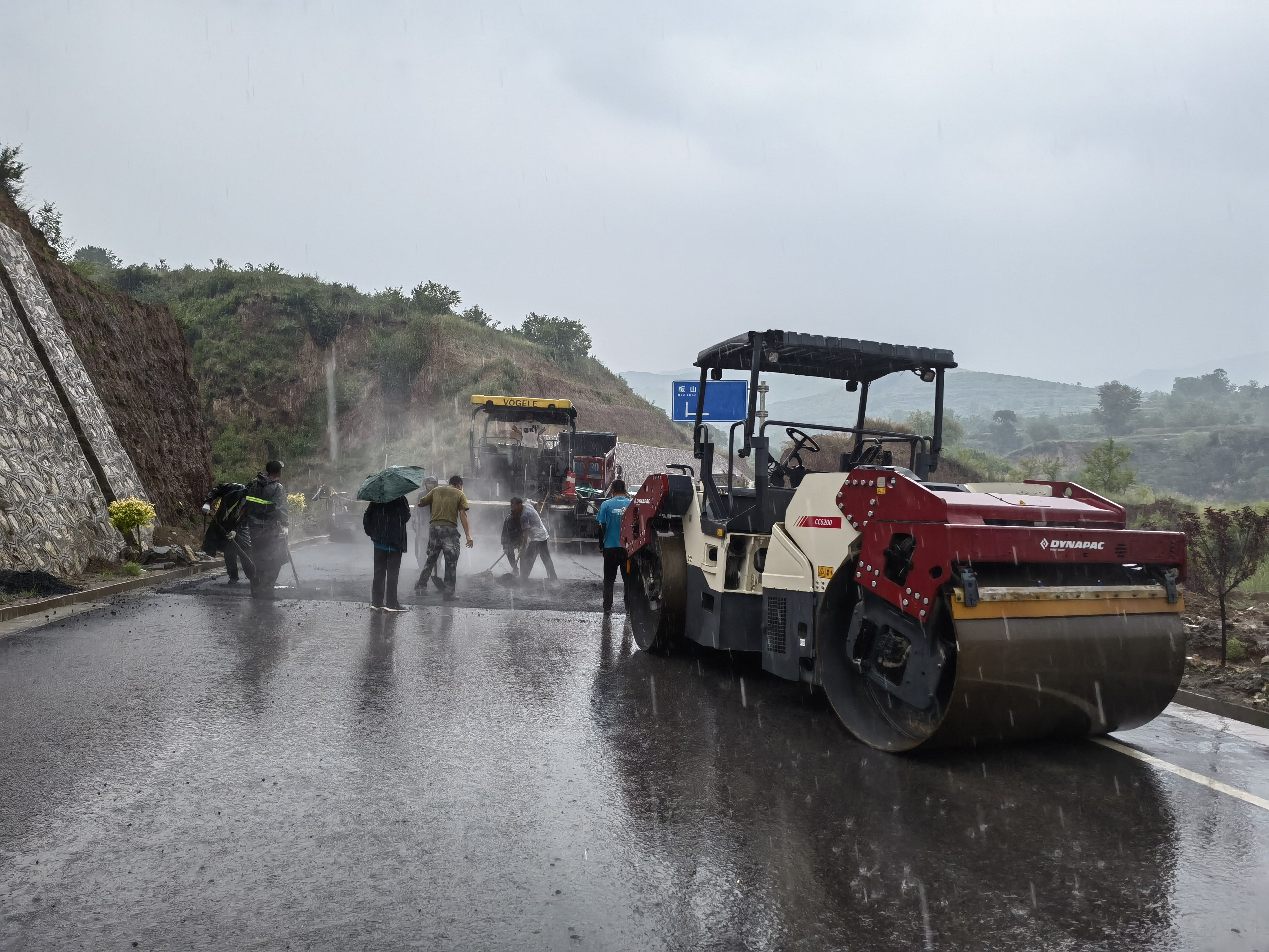 路橋工人在大雨中搶修道路。李華英 攝