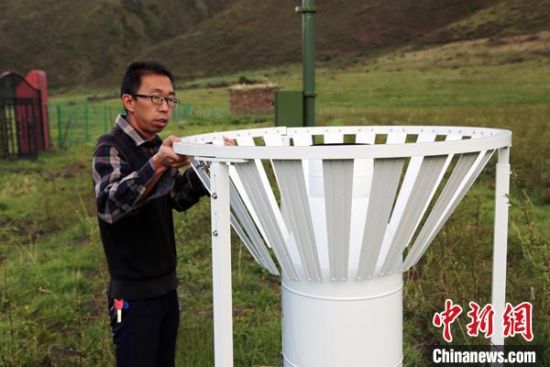 圖為班瑪縣氣象局工作人員在維護藏雪茶基地氣候站。青海省氣象局供圖