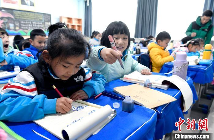 3月14日，西藏拉薩市第一小學一年級六班學生白瑪朗珍(圖左)在藏語文課上書寫藏文?！±盍?攝