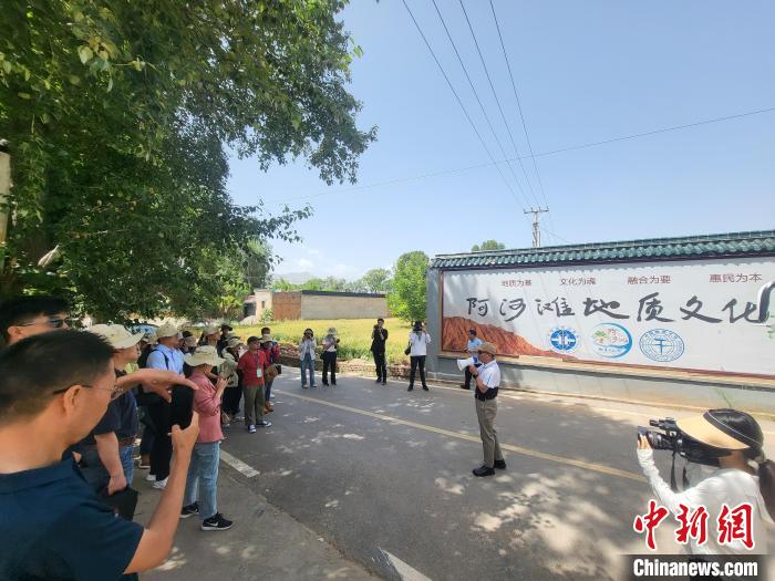 圖為中國地質大學(北京)教授張緒教介紹村落情況。　胡友軍 攝