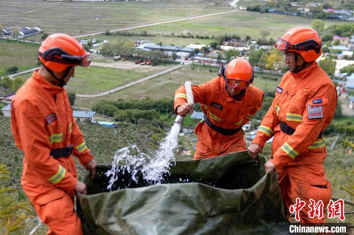 技能大練兵過程中，消防員在陡坡上向蓄水池注水?！±顕鵂c 攝