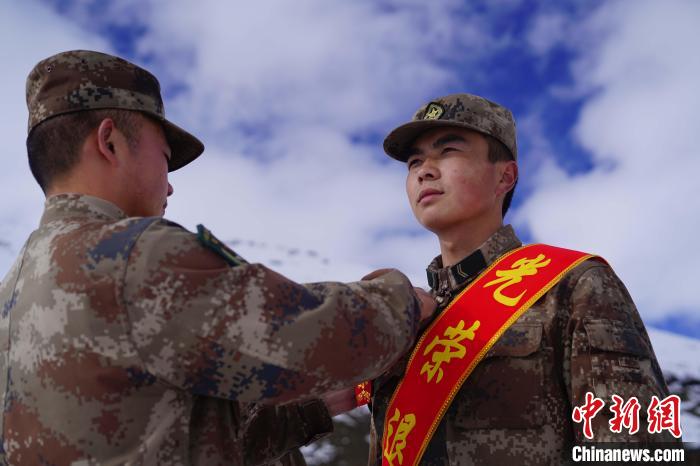 排長王朝偉(圖左)給退伍老兵佩戴大紅花。　西藏山南軍分區(qū)某團供圖