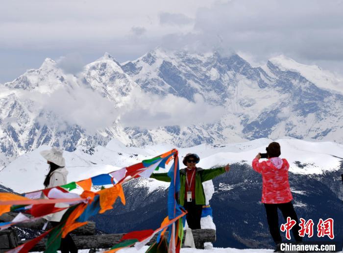 圖為5月14日，西藏林芝色季拉山觀景臺(tái)，游客與南迦巴瓦峰合影?！±盍?攝