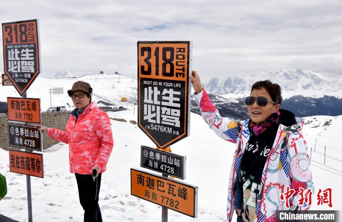 圖為5月14日，西藏林芝色季拉山觀景臺(tái)，游客與南迦巴瓦峰合影?！±盍?攝