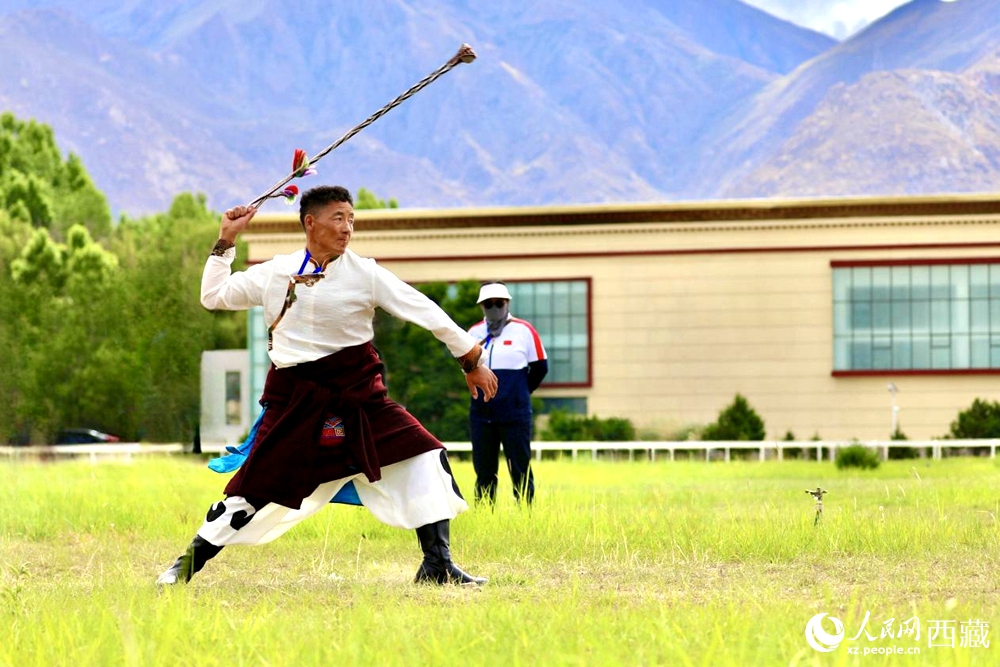 參賽選手在拉薩首屆農(nóng)牧民運(yùn)動(dòng)會(huì)上進(jìn)行“古朵”比賽（“古朵”指的是用牦牛毛或者山羊毛編織成的拋石繩，可以將石頭投擲到較遠(yuǎn)的地方，是牧民們用來(lái)放牧的工具）。