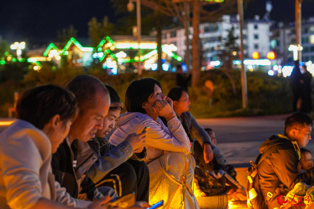 市民坐在西藏林芝市民族團結(jié)廣場臺階上欣賞音樂噴泉。人民網(wǎng)記者 趙晨攝